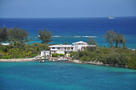 aerial photography of white concrete house near blue body of water at daytime thumbnail
