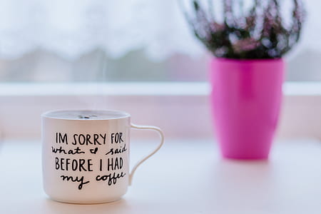 white and black ceramic mug on white table thumbnail