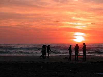 silhouette of six person walking beside seashore during sunset thumbnail