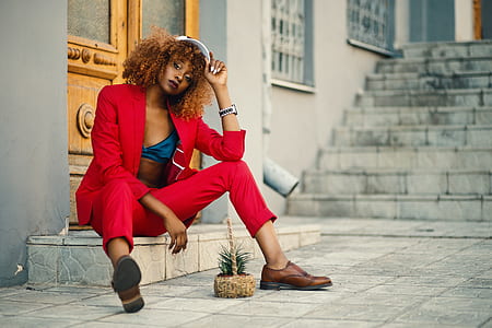 Woman Wearing Red Blazer and Pants Sitting on Marble Ground thumbnail