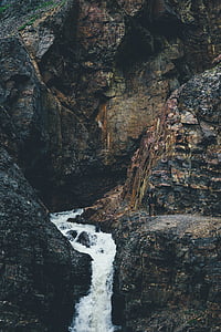 time-lapse photography of waterfalls surrounded with black and brown rock formations thumbnail