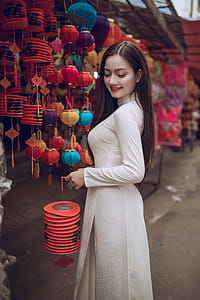 Woman in White Long-sleeved Dress Holding Lantern thumbnail