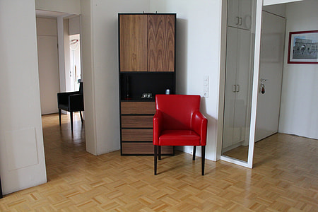black and red armchair beside brown wooden cabinet thumbnail