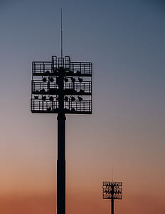 two metal towers with lights during golden hour thumbnail