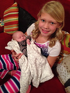 woman holding baby in gray jacket thumbnail