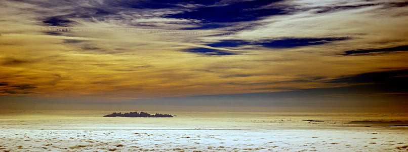 landscape photography of gray field under blue and gray sky thumbnail