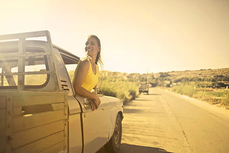 Young Beautiful Woman in Yellow Polo Shirt looking out from driver seat window of pick up truck thumbnail