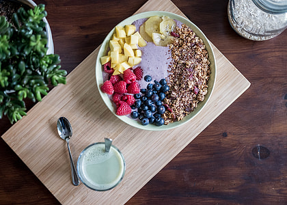 white ceramic bowl full of foods on brown serving tray thumbnail