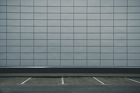 empty parking space near white building wall thumbnail