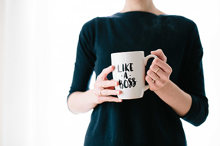woman standing while holding mug thumbnail