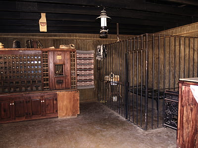 black metal cage beside brown wooden cabinet thumbnail
