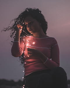 woman holding fairy lights during night time thumbnail