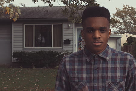 man standing in front house beside trees ] thumbnail