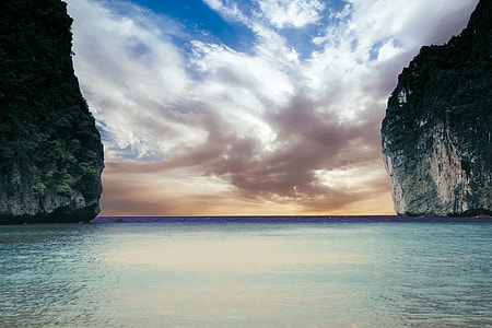 blue body of water and green rock formation thumbnail