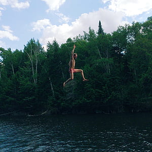 Man in Pink Shorts Jumping on Body of Water thumbnail