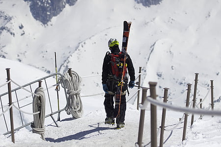 standing person wearing backpack walking on snow thumbnail
