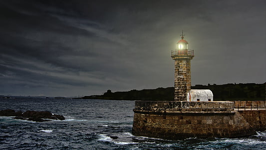 brown and gray concrete brick frame lighthouse near white shed thumbnail