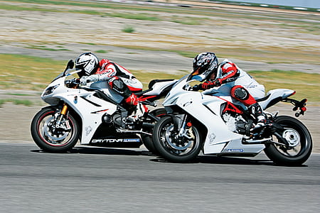 two racing motorcycles on road thumbnail
