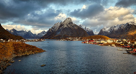 photo of city near mountains and body of water thumbnail