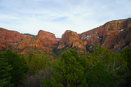 brown rock formations under blue and white sky thumbnail