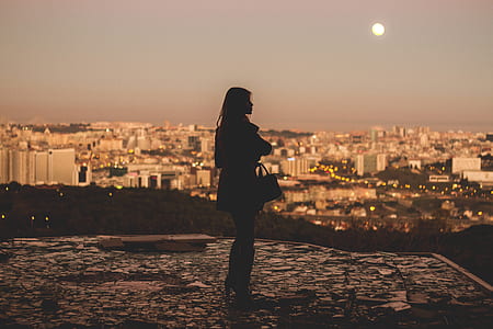 silhouette of woman standing in concrete field during sunset thumbnail