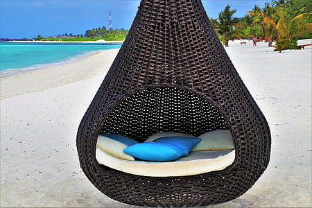 brown wicker swing chair on seashore thumbnail