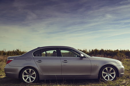 gray sedan parked on grass field thumbnail