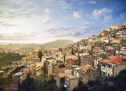 village under blue sky near mountain thumbnail