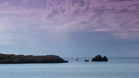 sailboat near rock formations thumbnail