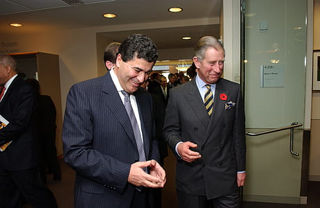 two men smiling and standing near white wall thumbnail