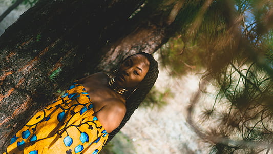 women wearing yellow and blue dress near green leafed tree thumbnail