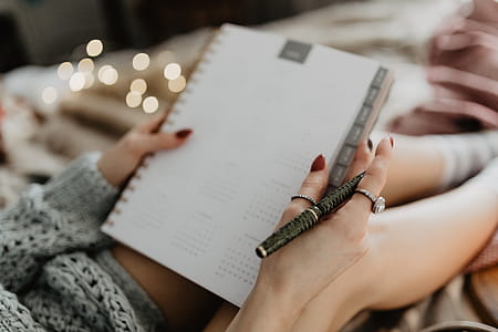 Writing in a notebook lying in bed, with coffee, candles, and gingerbreads thumbnail