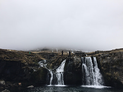 silhouette photo of person standing on waterfalls during daytime thumbnail