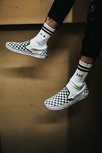 person wearing pair of white-and-black Vans low-top sneakers thumbnail