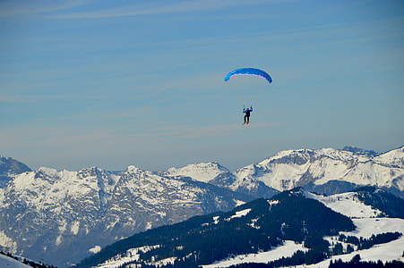 person paragliding above snow mountains thumbnail