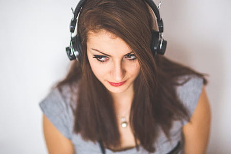 woman wearing gray calf-sleeved shirt and black wireless headphones thumbnail