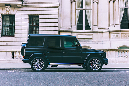 black Mercedes-Benz G-class SUV parked near concrete building during daytime thumbnail