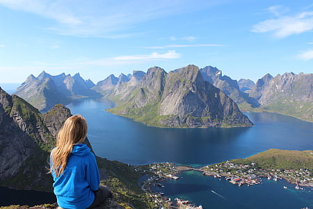 woman sitting on mountain looking in the body of water thumbnail