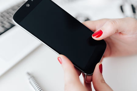 Businesswoman uses her mobile phone at her desk thumbnail