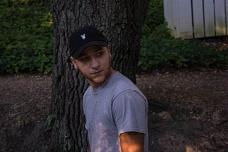 Photo of Man Wearing Gray Shirt Standing Near Tree thumbnail
