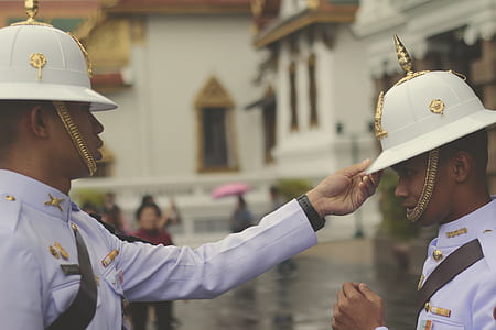 man in white uniform holding man's white hard hat thumbnail