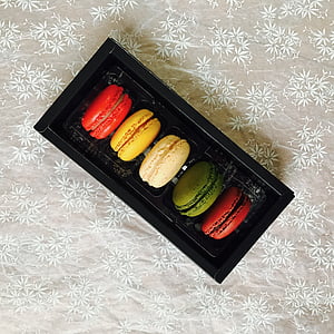 five macaroons inside black container thumbnail