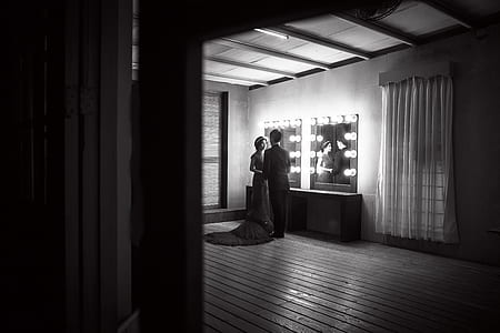 grayscale photo of couple in front of mirror thumbnail