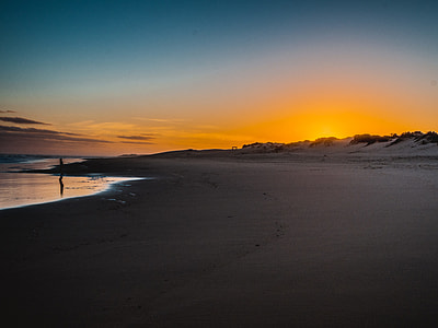 silhouette of person standing near seashore during dusk thumbnail