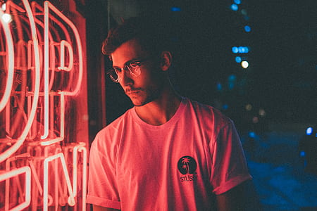 man standing near neon signage during night time thumbnail