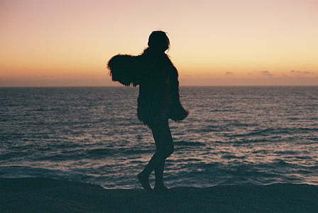 silhouette photo of person standing near body of water thumbnail