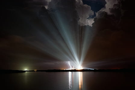 light under beside body of water under cloudy sky thumbnail