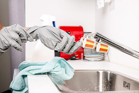 person wearing gloves near stainless steel faucet thumbnail