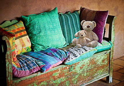 assorted-color throw pillows and two brown bear plush toys thumbnail
