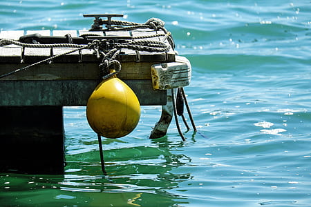 yellow buoy hanging on dock thumbnail